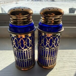 Vintage cobalt blue glass and silver-plated salt and pepper shakers.